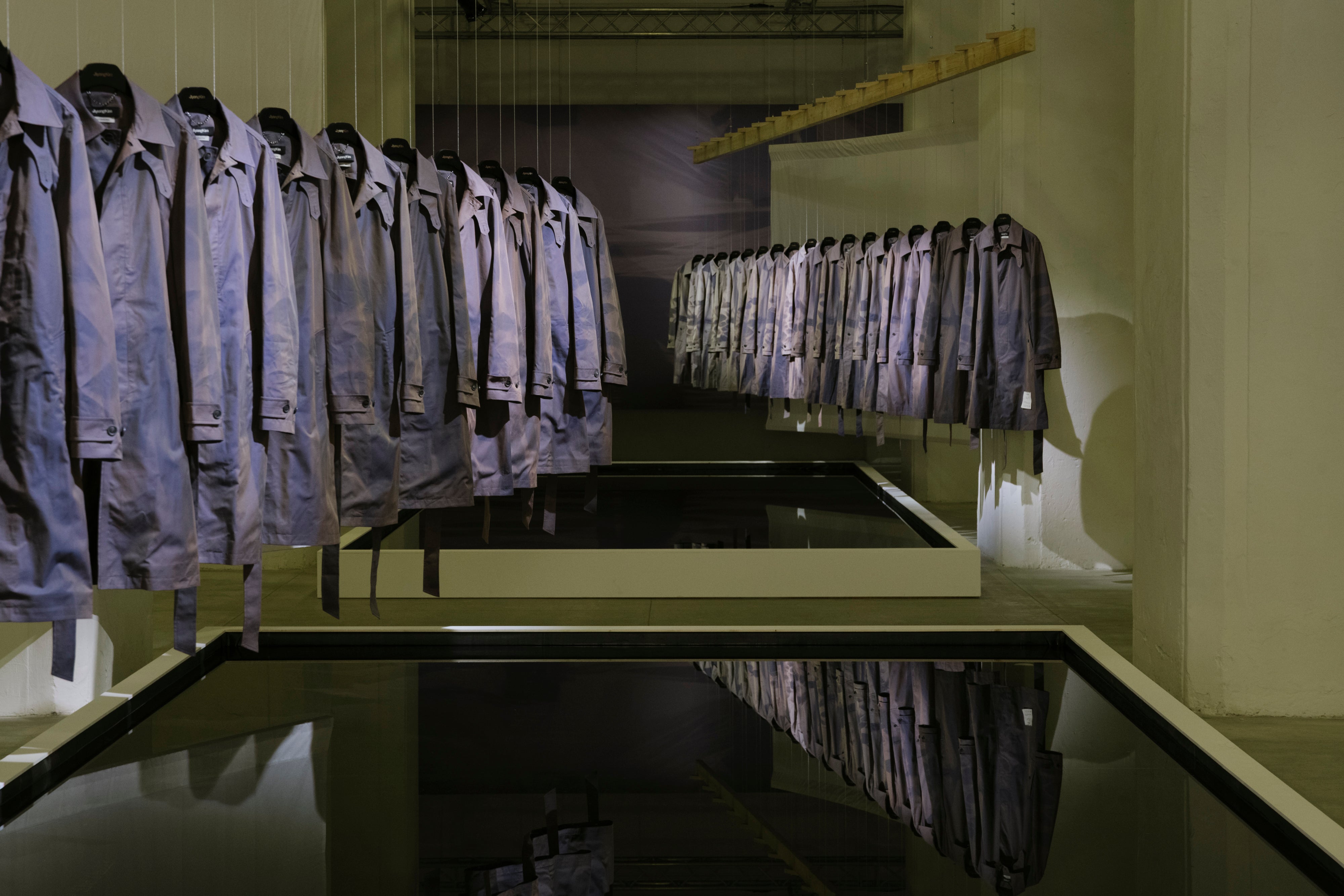 JiyongKim sun-bleached trench coats suspended over reflective water installations at Pitti Uomo 110 Magazzino 07